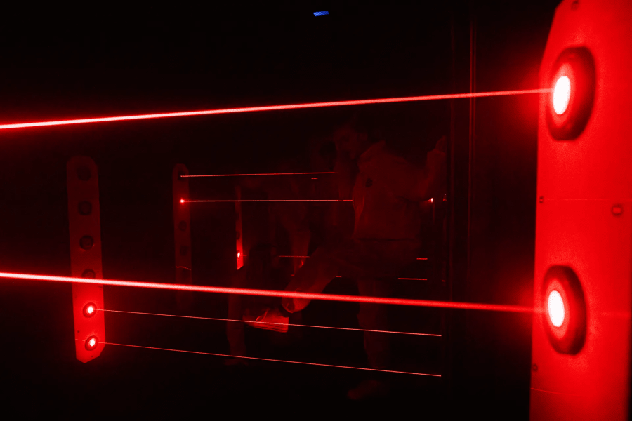People trying to cross the room hidding from the lasers.