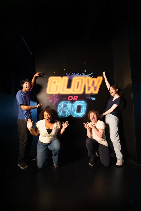 Group taking a selfie in front of the glow or go logo